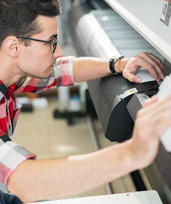 Technicien répare un traceur grand format